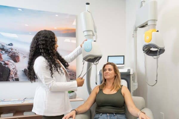 Clinician positioning the TMS coil for a patient during a treatment session